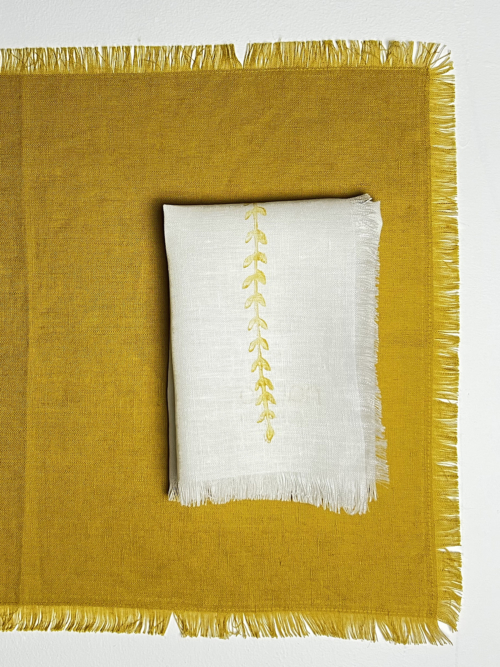 gold wheat in a line frayed french linen napkin folded